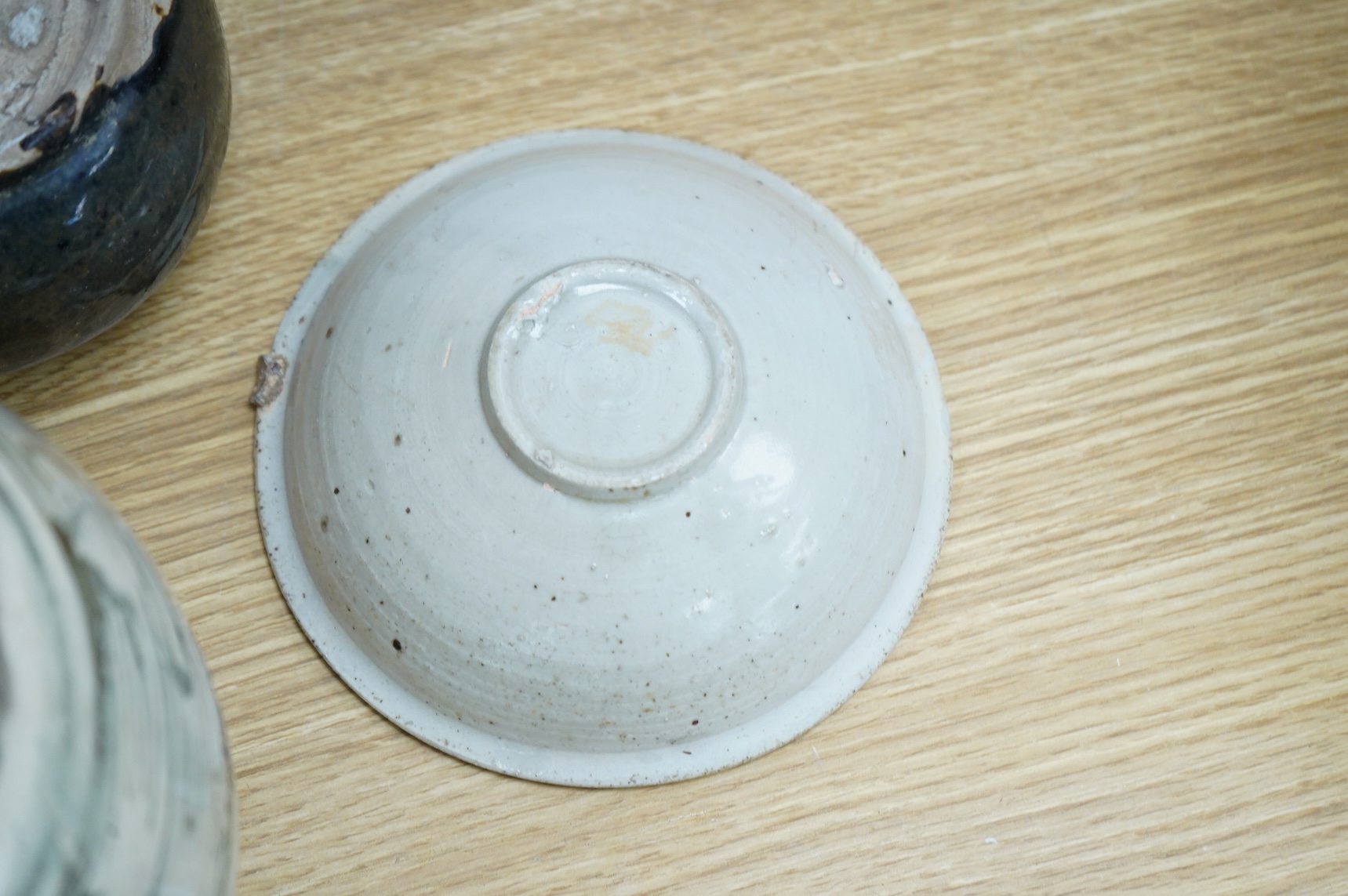 A collection of Chinese pottery jars and a decorated plate, tallest jar 18cm high